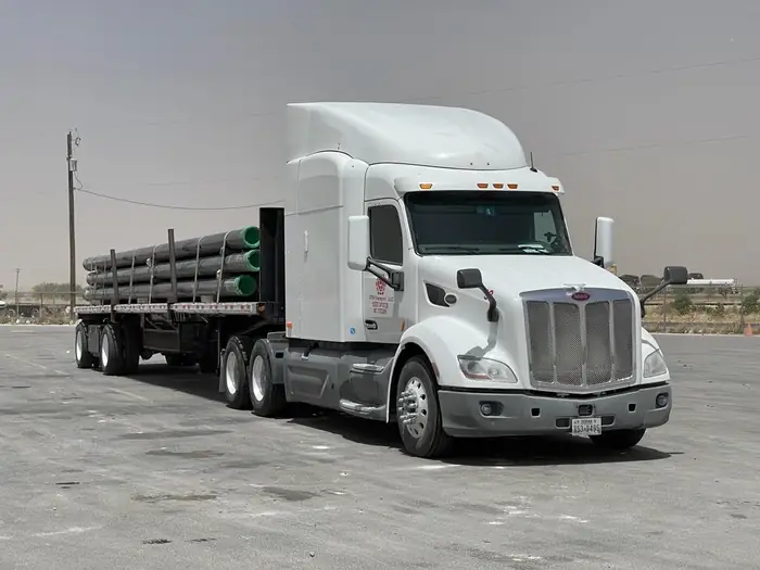 GTM Transport grey Kenworth flatbed hauling wellsite pump units