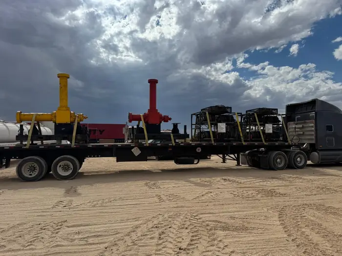 GTM Transport flatbed trailer loaded with wellhead valves and pump jacks