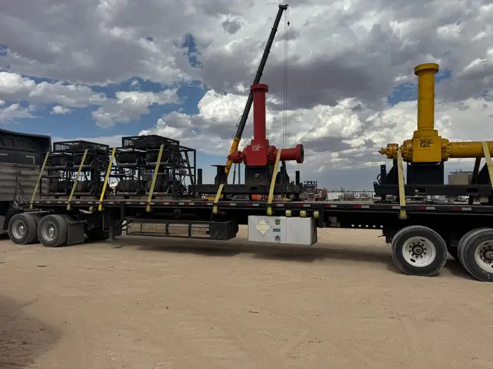 GTM Transport flatbed loaded with wireline reels and a mobile crane